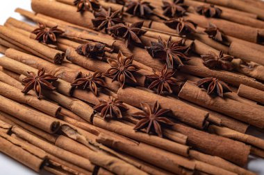 Fragrant spices for preparing drinks and desserts. Food additive in dishes. Brown spices. Spices for making mulled wine. A lot of star anise on cinnamon rolls top view