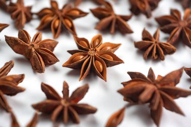 Fragrant spices for preparing drinks and desserts. Food additive in dishes. Brown spices. Spices for making mulled wine. A lot of star anise on a white background close-up