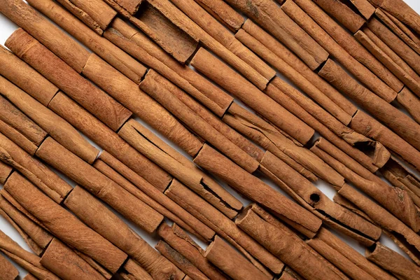 Fragrant spices for preparing drinks and desserts. Food additive in dishes. Brown spices. Spices for making mulled wine. Many cinnamon rolls stacked in an even order, top view