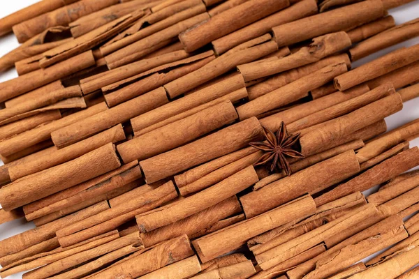 Fragrant spices for preparing drinks and desserts. Food additive in dishes. Brown spices. Spices for making mulled wine. Star anise lies on a large number of cinnamon rolls