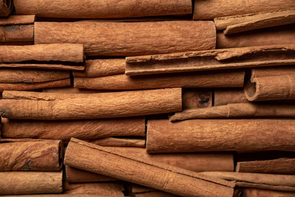 Fragrant spices for preparing drinks and desserts. Food additive in dishes. Brown spices. Spices for making mulled wine. Many cinnamon rolls stacked in an even order, top view