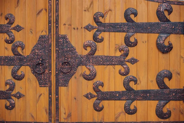 Wooden gate with metal decorative forging on both sides. Decorative texture