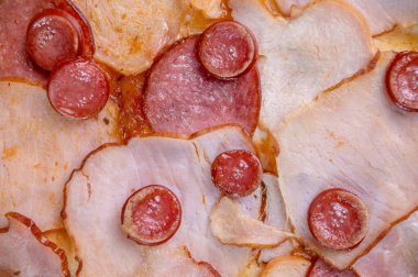freshly made pizza close-up; details of the pizza application; juicy pizza from the oven with mushrooms, tomatoes and bacon and sprinkled with parmesan cheese