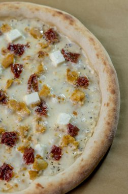 freshly made pizza close-up; details of the pizza application; juicy pizza from the oven with mushrooms, tomatoes and bacon and sprinkled with parmesan cheese