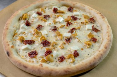 freshly made pizza close-up; details of the pizza application; juicy pizza from the oven with mushrooms, tomatoes and bacon and sprinkled with parmesan cheese