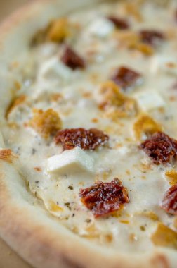 freshly made pizza close-up; details of the pizza application; juicy pizza from the oven with mushrooms, tomatoes and bacon and sprinkled with parmesan cheese