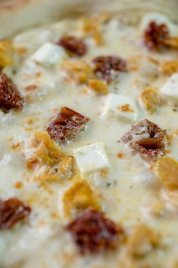 freshly made pizza close-up; details of the pizza application; juicy pizza from the oven with mushrooms, tomatoes and bacon and sprinkled with parmesan cheese