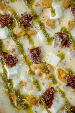 freshly made pizza close-up; details of the pizza application; juicy pizza from the oven with mushrooms, tomatoes and bacon and sprinkled with parmesan cheese