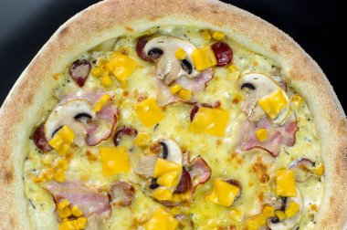 freshly made pizza close-up; details of the pizza application; juicy pizza from the oven with mushrooms, tomatoes and bacon and sprinkled with parmesan cheese