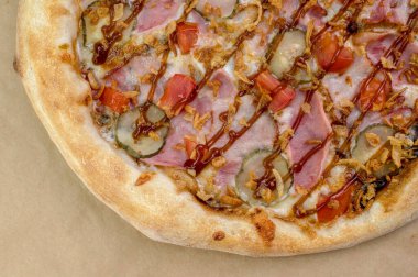 freshly made pizza close-up; details of the pizza application; juicy pizza from the oven with mushrooms, tomatoes and bacon and sprinkled with parmesan cheese