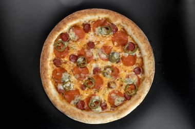 freshly made pizza close-up; details of the pizza application; juicy pizza from the oven with mushrooms, tomatoes and bacon and sprinkled with parmesan cheese