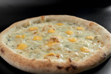 freshly made pizza close-up; details of the pizza application; juicy pizza from the oven with mushrooms, tomatoes and bacon and sprinkled with parmesan cheese