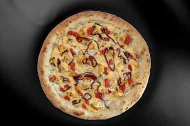 freshly made pizza close-up; details of the pizza application; juicy pizza from the oven with mushrooms, tomatoes and bacon and sprinkled with parmesan cheese