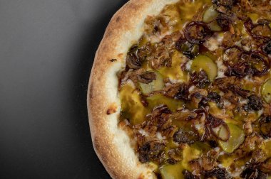 freshly made pizza close-up; details of the pizza application; juicy pizza from the oven with mushrooms, tomatoes and bacon and sprinkled with parmesan cheese