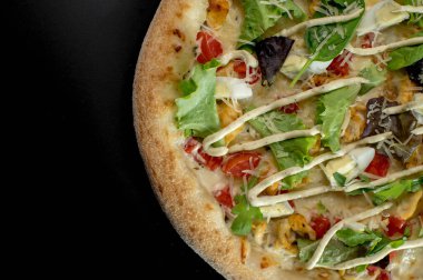 freshly made pizza close-up; details of the pizza application; juicy pizza from the oven with mushrooms, tomatoes and bacon and sprinkled with parmesan cheese