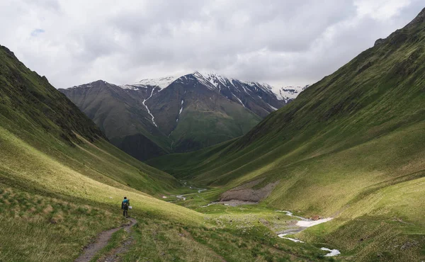 Snow Capped Mountain Green Hills Landscaped Man Trekking Alone Summer — Stock fotografie