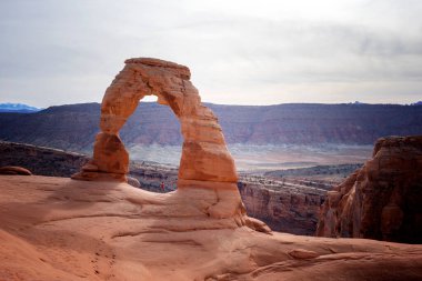 I was standing under Delicate Arch in Arches National Park. Weak afternoon sun shining on the rock formation.  clipart