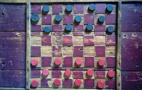 Dallas Heritage Village 'da sergilenen eski bir ahşap dama tahtası. Işıklar sol taraftan geliyor. Ahşap dokusu renk ve ışıklarla güçlendirildi.. 