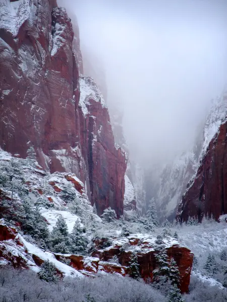 stock image Zion National Park north entrance in December winter season. Snow drifted away from north. Fog and light snow in the air, covering the mountain, valley, canyons and tree tops. 