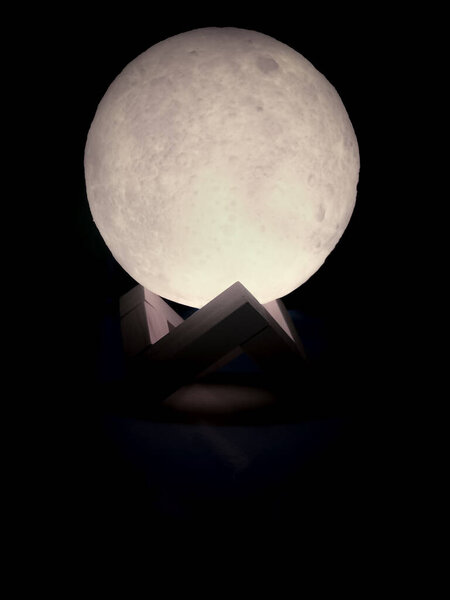 The Light Bulb Toy That Look Like a Moon Surface supported by geometrically shaped wood
