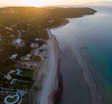 Gün batımında bir sahil şeridinin havadan görünüşü.