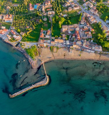 İskelesi ve turkuaz suyu olan kıyı kasabasının havadan görüntüsü..