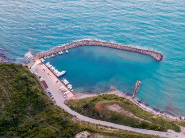 Tekneli küçük bir liman ve sakin bir turkuaz deniz manzarası..