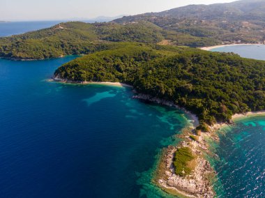 Turkuaz sularla buluşan yemyeşil adaların havadan görünüşü.
