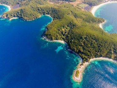 Turkuaz sularla buluşan yemyeşil adaların havadan görünüşü.