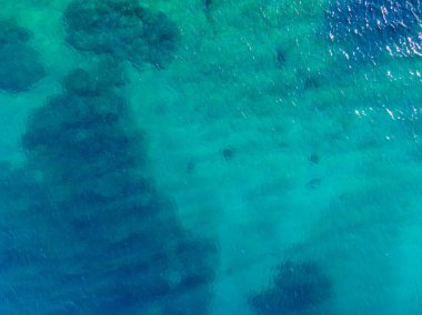 Çakıl taşlı bir plajda sürüklenirken kristal berrak turkuaz suyla karşılaşır..