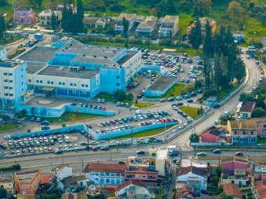 Otoparkları ve çevresindeki yerleşim alanları olan bir hastane kompleksinin havadan görüntüsü..