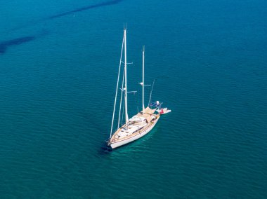 Denizde lüks bir yelkenli, hava manzaralı. Sakin sular, güneşli bir gün.