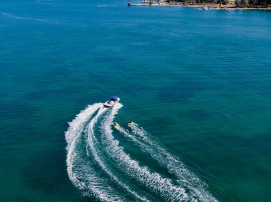 Güneşli bir günde tekne teknesini çekiyor. Turkuaz suyun ve yaz eğlencesinin tadını çıkar.!