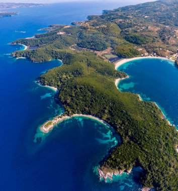 Göz kamaştırıcı turkuaz koyları ve berrak mavi okyanusuyla yemyeşil bir yarımadanın havadan görünüşü..