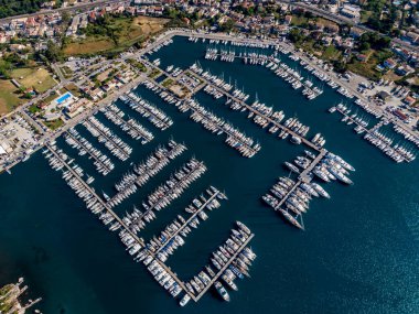 Yat ve teknelerle dolu bir marinanın havadan görüntüsü. Canlı bir rıhtım manzarası.