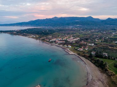 Kıyı kasabası turkuaz deniz ve dağlar arasına kurulmuş. Sakin bir hava manzarası.