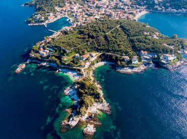 Sahil kasabası ve ıssız plaj yukarıdan görünüyor. Kristal berraklığında turkuaz sular resim gibi bir yarımadanın etrafını sarıyor..