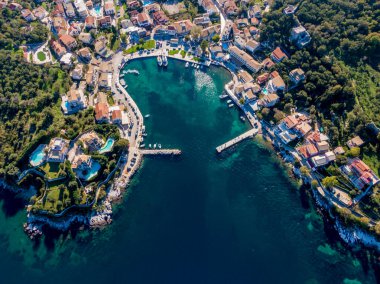 Sahil köyünün hava manzarası. Huzurlu bir körfeze bakan bir yamaçta tekneli evler..