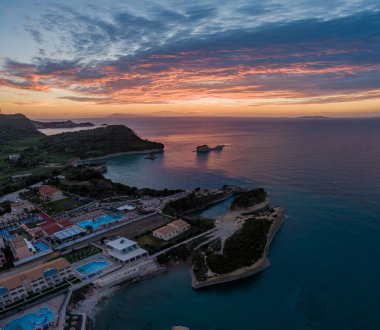 Muhteşem okyanus manzaralı sahil üzerinde gün batımı. Güneş ufukta batarken nefes kesici renkler gökyüzünü boyuyor..