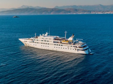 Lüks yolcu gemisi sakin okyanus sularında yol alıyor, uzaktaki dağlar....