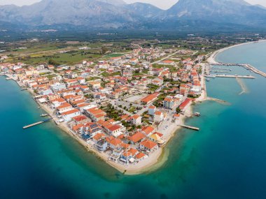 Kıyı kasabası dağlarla denizin arasına kurulmuş. Resimli binaların ve berrak suların çarpıcı hava manzarası.