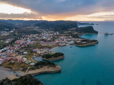 Gün batımında sahil kasabası, manzaralı hava manzarası. Turkuaz sular ve dramatik uçurumlar.