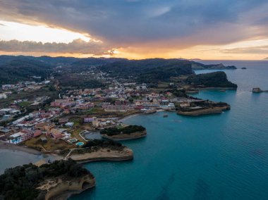 Sahil kasabasının günbatımı hava manzarası. Çarpıcı turkuaz sular ile altın saat göğü karşılıyor..