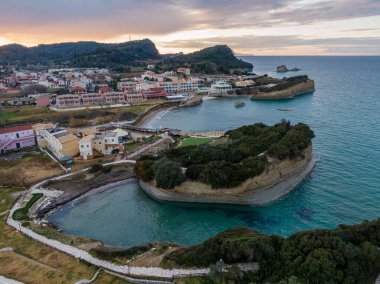 Gün batımında sahil kasabası, turkuvaz suları ve yemyeşil yemyeşil manzaralı körfez..