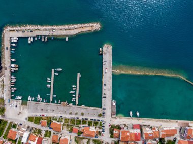 Bir sahil kasabasında yuva yapmış, teknelerle dolu pitoresk bir limanın havadan görünüşü. Sakin sular büyüleyici mimariyle buluşur..