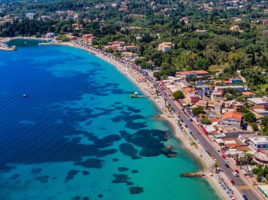 Sahil kasabasının hava manzarası: turkuaz su, kumlu sahil, yol, binalar, yemyeşil alan. Mükemmel yaz kaçamağı.!