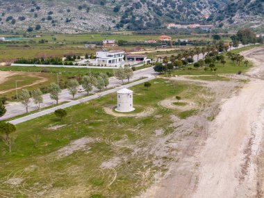 Kıyı yel değirmeni ve yukarıdan görünen modern ev. Yeşil ve plajlı sakin bir manzara..