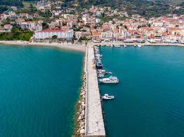 Sahil kenti limanında tekneler ve turkuaz su var. Deniz kıyısındaki bir köyün resimli hava görüntüsü..