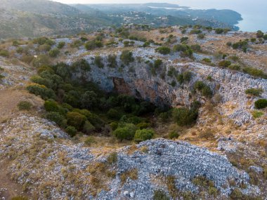 Kayalık bir arazideki subatan manzarası, yemyeşil bitki örtüsü gri taşla çelişiyor..