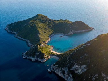 Yeşil tepelerin arasına gizlenmiş tenha bir koy, güneş ışığında parıldayan turkuaz sular. Gizli bir cennet.